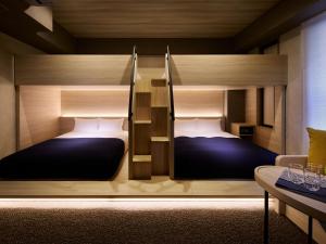 two bunk beds in a room with a table at Minn Namba Nipponbashi in Osaka