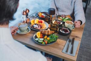 two people sitting at a table with plates of food at Wilderness Hotel Saariselkä in Saariselka
