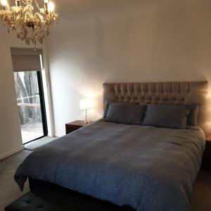 a bedroom with a large bed and a chandelier at Lake View Cottage in Metricup
