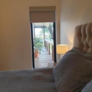 a bedroom with a bed and a door to a deck at Lake View Cottage in Metricup +22 photos