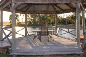 a wooden gazebo with a table and chairs at Lake View Cottage in Metricup