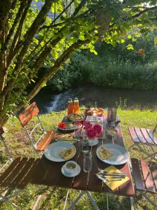 a picnic table with food on it next to a river at Hotel Hirsch Fluorn Schwarzwald in Fluorn