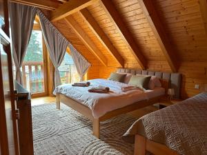 a bedroom with two beds in a log cabin at Chata Mila in Veľká Lomnica