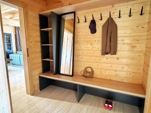 a room with a wooden wall with a shelf and a coat at Chata Mila in Veľká Lomnica +19 photos