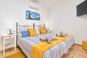 a bedroom with a bed with yellow and blue pillows at El Rincón de Esther in Cómpeta +27 photos