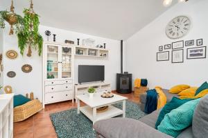 a living room with a couch and a tv at El Rincón de Esther in Cómpeta