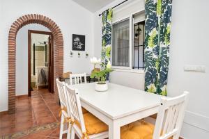 a dining room with a white table and chairs at El Rincón de Esther in Cómpeta