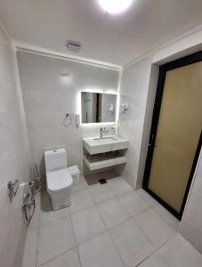 a bathroom with a toilet and a sink and a mirror at إقامة مريحة وممتعة في شارع الاميرات in Baghdād +28 photos