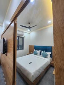 a bedroom with a large bed with a ceiling at Hotel Namaste Ac Rooms in Vadodara +6 photos