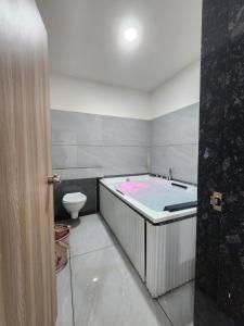 a bathroom with a bath tub and a toilet at Hotel Namaste Ac Rooms in Vadodara