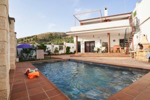 a house with a swimming pool in front of a house at La Majailla in Peal de Becerro