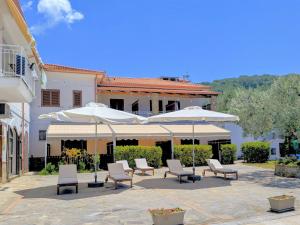 a patio with chairs and umbrellas in front of a building at Tenuta Marga in Agnone