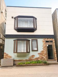 a house with two windows on the side of it at Sapporo Nakajima Parkhouse in Sapporo