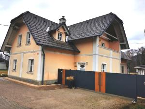 a house with a fence in front of it at Apartmaji ARKO in Ribnica