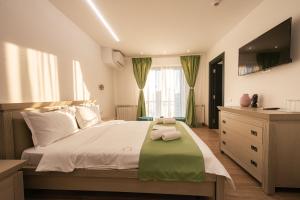 a bedroom with a large bed with a television on it at Escape Vama Veche in Vama Veche