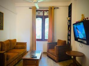 a living room with a couch and a tv at Raniya Villa in Bentota