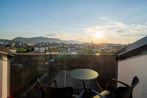 a balcony with a table and chairs and a view at Grand Station Hotel in Shkodër