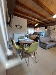 a living room with a table and chairs and a kitchen at The Mastiha Spot 8 in Chios