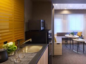 a kitchen with a sink and a living room at Minn Namba Nipponbashi in Osaka +16 photos