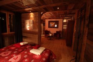 um quarto com uma cama num chalé de madeira em Chambres d'hôtes de charme Douglas em Samoëns
