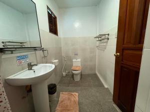 a bathroom with a sink and a toilet at Latitude 10 Siargao in General Luna