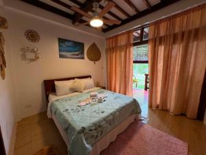 a bedroom with a bed and a large window at Latitude 10 Siargao in General Luna