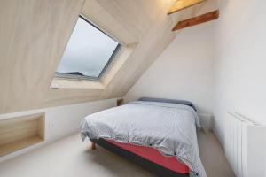 a small bedroom with a bed and a window at Appartement rénové centre Crozon in Crozon