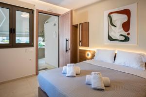 a bedroom with a bed with towels on it at Citrus 5 Urban Studios in Mastambás