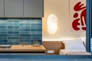 a kitchen with a sink and a bed in a room at Citrus 5 Urban Studios in Mastambás +47 photos