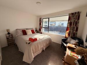 a bedroom with a bed and a window and a chair at B&B on Hoffman in Hokitika +11 photos