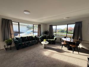 a living room with couches and a table and chairs at B&B on Hoffman in Hokitika