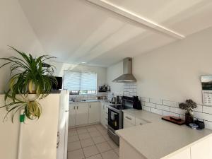 a kitchen with white cabinets and a white refrigerator at B&B on Hoffman in Hokitika