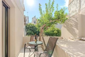 a small table and chairs on a balcony with a tree at Citrus 5 Urban Studios in Mastambás