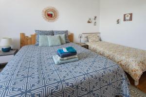 a bedroom with a bed with a blue and white comforter at Demeure Olea, Chambres D'hôtes in Chérac