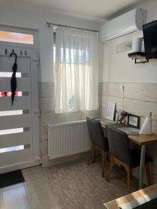 a dining room with a table and a window at Móra apartman 3. in Kiskunfélegyháza