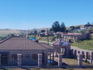 a house with a fence in front of a street at Zamdu Lodge in Nkandla