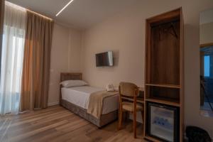 a hotel room with a bed and a television at Grand Station Hotel in Shkodër