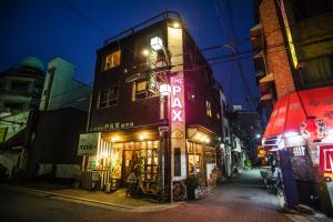 a building with a neon sign on the side of it at The Pax Hostel in Osaka