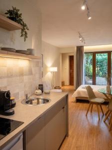 a kitchen with a sink and a room with a bed at Sétány Apartman-és Vendégház in Tiszafüred