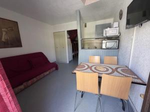 a small room with a table and chairs and a couch at Centre village, proche toutes commodités in Les Angles