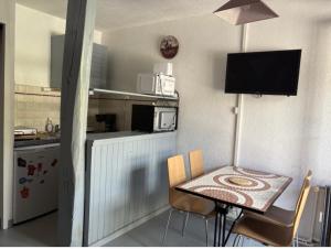 a small kitchen with a small table and a table and chairs at Centre village, proche toutes commodités in Les Angles