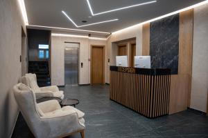a lobby with chairs and a reception desk in a building at Grand Station Hotel in Shkodër