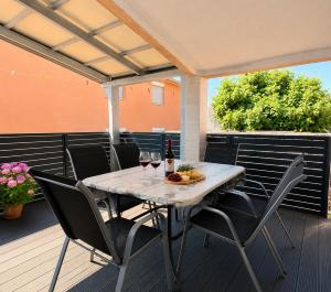 a table with two glasses of wine on a deck at Apartmani Catakovic in Vir +26 photos