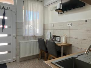 a kitchen with a table with chairs and a sink at Móra apartman 3. in Kiskunfélegyháza