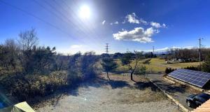 a solar panel next to a river with a field at すずめのとまりぎ in Nasu