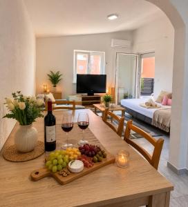 a living room with a table with wine glasses and grapes at Apartmani Catakovic in Vir