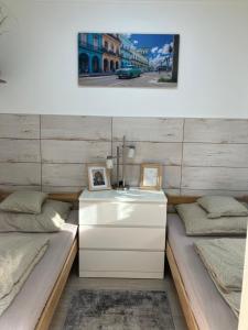 a room with two beds and a white dresser at Móra apartman 3. in Kiskunfélegyháza