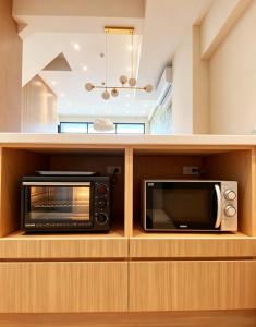 a kitchen with a microwave and a toaster oven at 大溪漁港蜜月灣Luna民宿 in Fan-shu-liao