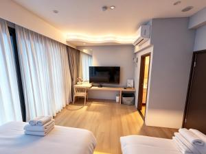 a hotel room with two beds and a desk with a television at 大溪漁港蜜月灣Luna民宿 in Fan-shu-liao +119 photos