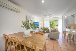 a dining room and living room with a table and chairs at Riverside Retreat, Noosaville in Noosaville
